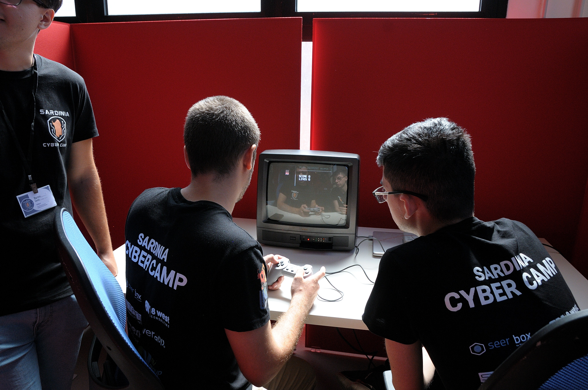 Partecipanti riuniti attorno a una console retro durante la sfida speedrun
